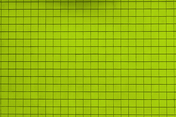 Grüne Wand mit quadratischen kleinen Kacheln. Geflieste grüne Hintergrund Textur.

