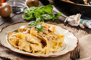 Pappardelle pasta with prosciutto and cheese sauce on a plate