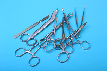 Close Up Surgical instruments and tools on blue mirror background. Selective focus.