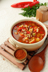Bulgarian potato soup with paprika and minced meat in a ceramic bowl