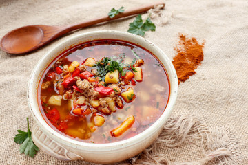 Bulgarian potato soup with paprika and minced meat in a ceramic bowl