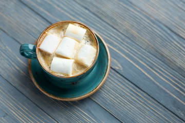 Cup of coffee, marshmallow on wooden background. Warm lights. Cozy winter morning.  Lifestyle concept. Selective focus.