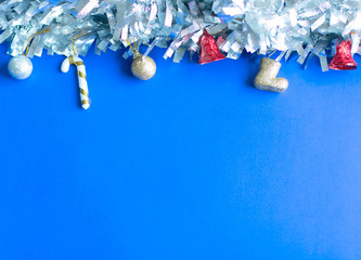 Christmas background; silver and gold balls and trinkets on blue background with copy space.