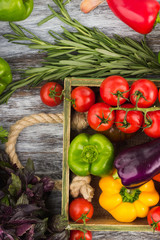 Set of different fresh raw colored vegetables in the wooden tray
