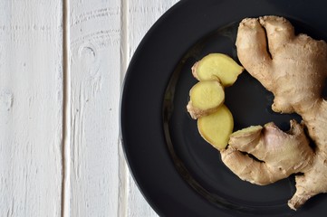 sliced ginger on black plate