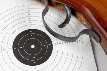 Shield and pneumatic weapon on a white table. Accessories for sport shooting at the shooting range.