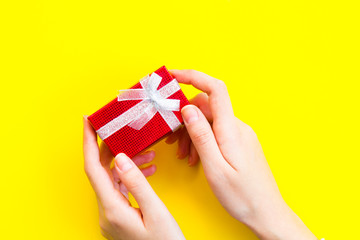 red gift pack on yellow background. Top view.