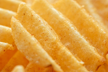 Appetizing peeled chips with paprika. Food chips background. Food Background.