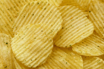 Appetizing peeled chips with paprika. Food chips background. Food Background.
