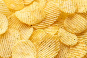 Appetizing peeled chips with paprika. Food chips background. Food Background.