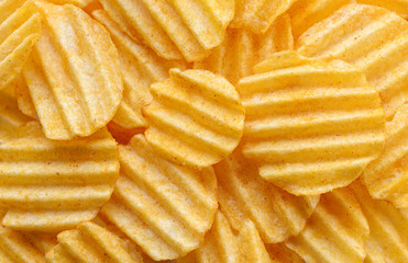 Appetizing peeled chips with paprika. Food chips background. Food Background.