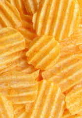 Appetizing peeled chips with paprika. Food chips background. Food Background.