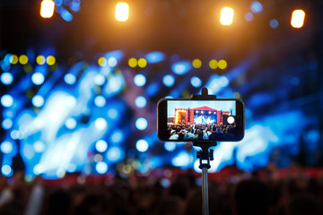 Smartphone on selfie monopod stick. show background