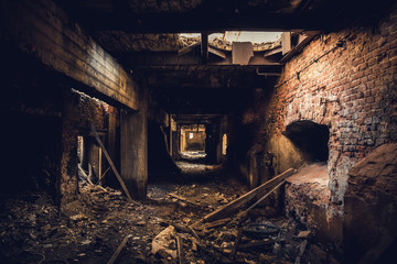 Dark corridor in ruined abandoned brick factory interior, creepy way to freedom and horror concept