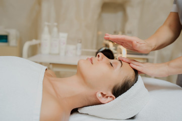 Obraz na płótnie Canvas Lateral view of a Woman having curative facial massage.