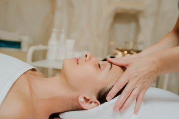 Fototapeta na wymiar Lateral view of a Woman having curative facial massage.