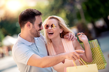 Young happy couple with shopping bags in the city