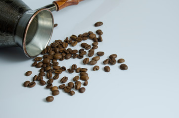 Coffee grains and copper turk for brewing coffee on a white background