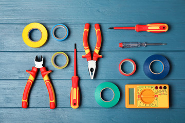 Flat lay composition with electrician's tools on wooden background - obrazy, fototapety, plakaty