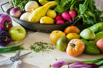 A kitchen scene with snipped chives and freshly washed vegetables.