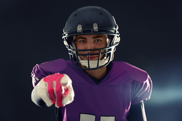 American football player in uniform on dark background