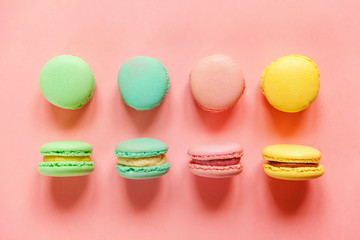 Sweet almond colorful pink biue yellow green macaron or macaroon dessert cake isolated on trendy pink pastel background. French sweet cookie. Minimal food bakery concept. Flat lay top view copy space