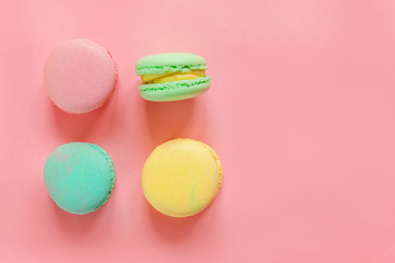 Sweet almond colorful pink biue yellow green macaron or macaroon dessert cake isolated on trendy pink pastel background. French sweet cookie. Minimal food bakery concept. Flat lay top view copy space