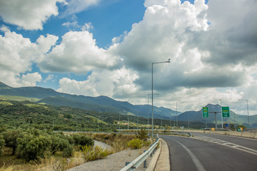 empty highway road and nature landscape environment with mountain horizon background in cloudy blue vivid sky