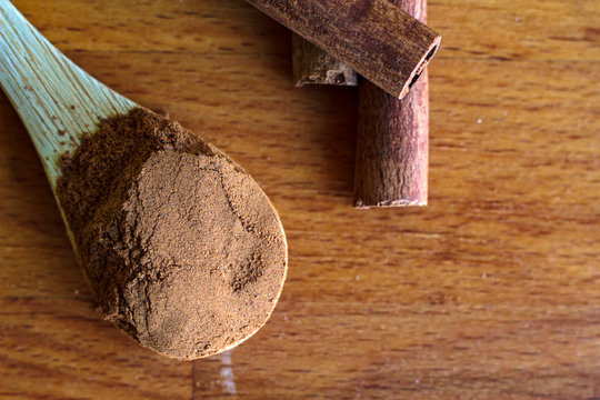 Top view of Cinnamon powder and Cinnamon sticks on wooden background
