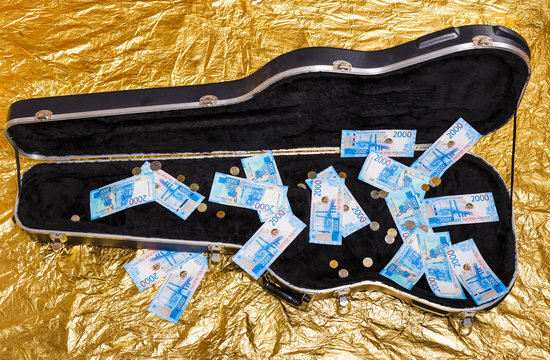 Russian Rubles Money Bills In Buskers Guitar Case On Gold Background.