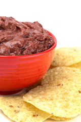 Bowl of Black Bean Dip with Chips on a White Background