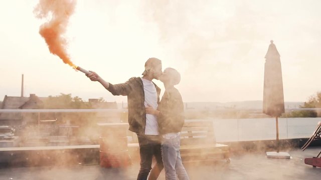 Handsome young man kisses his girlfriend romantically on the terrace