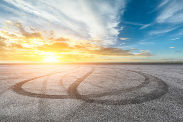 Asphalt road pavement and dramatic sky with coastline panorama at sunset