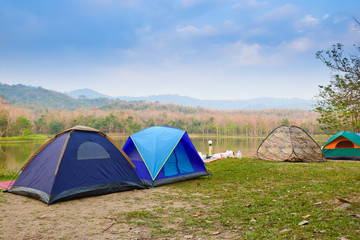 camping tent on the green grass around riverside.