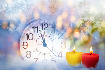 Clock face and Christmas candles lights in the frosty background