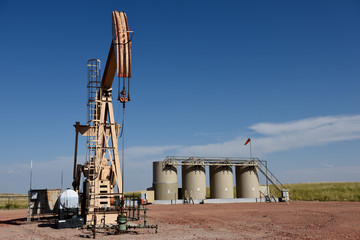 Pump jack and crude oil production storage tanks, Powder River Basin, with copy space.