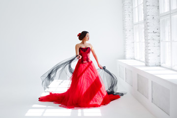 A young woman in a red dress is dancing. Latin style. Isolate on white