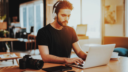 Stylish Guy in Headphones Use Laptop at Workplace