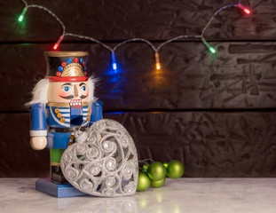 Christmas season nutcracker toy soldier traditional figurine with bokeh background over rustic background with writing space
