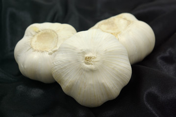 黒い布の上にある三つのニンニク