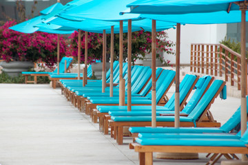 Fototapeta premium Umbrellas and deckchairs promise rest, relaxation and a break from the routine of everyday. Landscape orientation. Copy space.