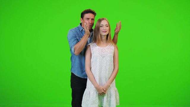 Hsband holds his hands over his wife eyes, surprises her, she is amazed, hugs him while he spins her over green screen.