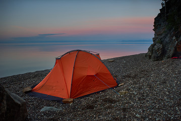 Tent near lake shore at the beautiful sunset