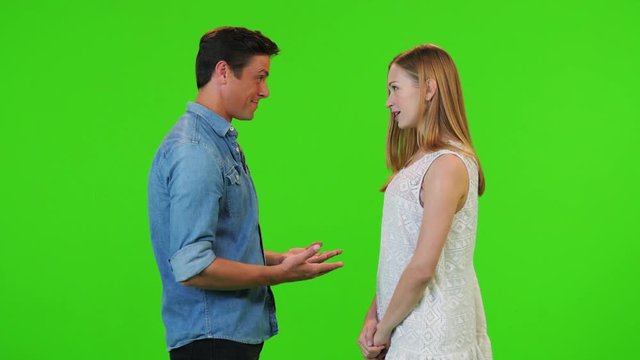 in love excited couple looks at each other dramatically , just before a proposal, over a green screen,