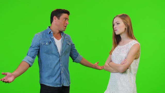 a man tries to cool and make peace with his angry wife/girlfriend, succeeds and hugs her over a green screen.
