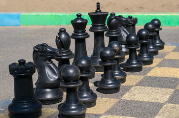 big black chess set standing on asphalt road on the street