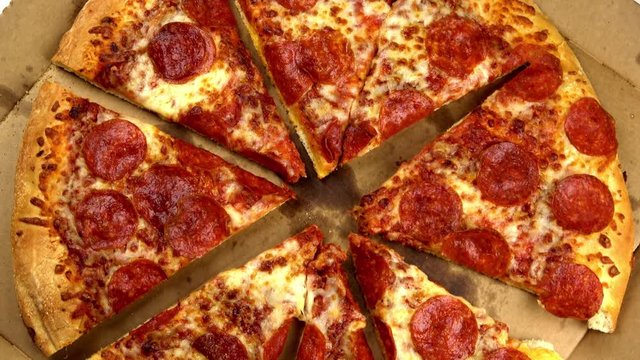 Spaced out slices pepperoni pizza spinning video close up