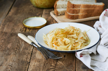 Sauerkraut with onions in a bowl on a wooden table