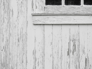 Old weathered wood boards or siding. Wooden planks on a wall with window. Light neutral flat faded toned texture.