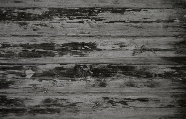 Dark black and white weathered wood surface with long boards lined up. Wooden planks on a wall or floor with grain and texture. Light neutral flat faded tones.